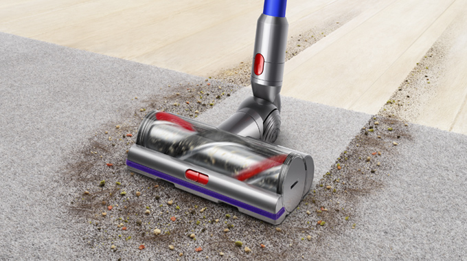 Dyson V11 dammsuger upp mycket smuts från en matta.