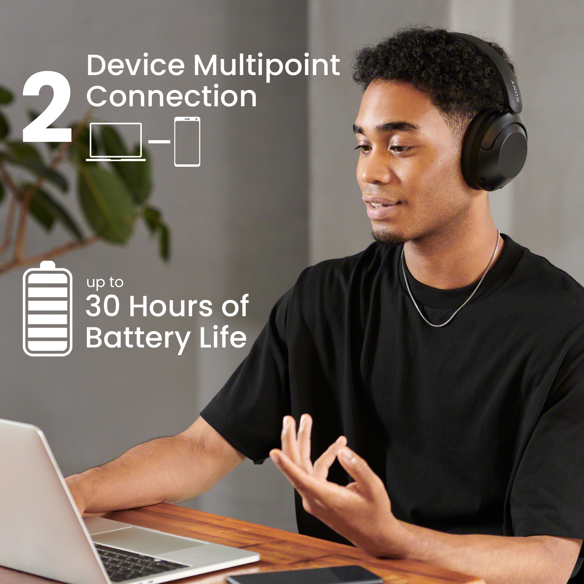 Ung mörk man med WH-XB910 hörlurar och laptop och engelsk text om batterikapacitet och anslutning mellan olika enheter
