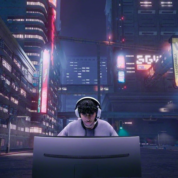 Man som har på sig Sony Inzone H9 trådlöst brusreducerande gaming headset och sitter framför en skärm på en gata i en mörk stad
