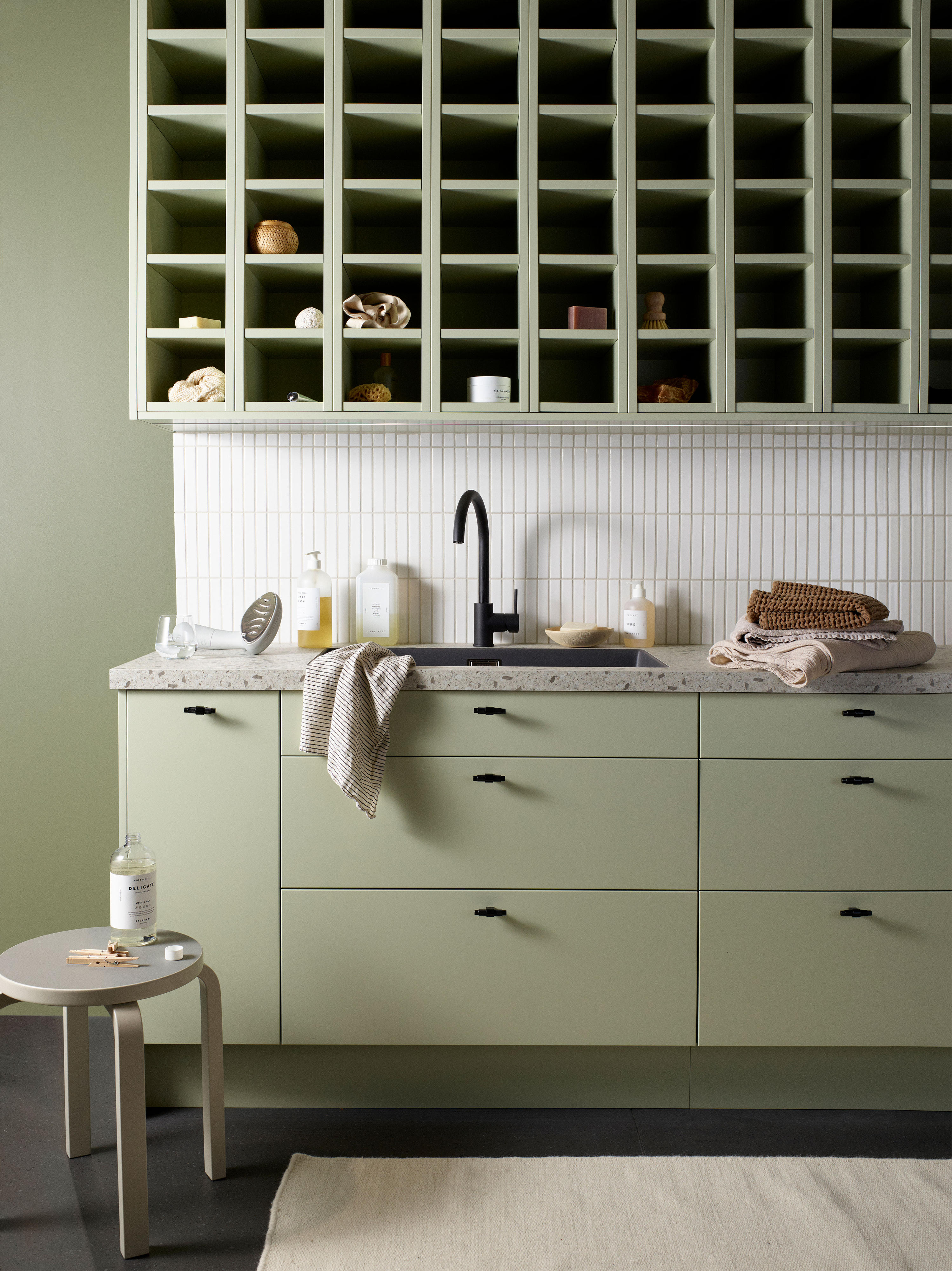 Epoq Trend Pistachio kitchen with a black sink, teatowels and a chair in front