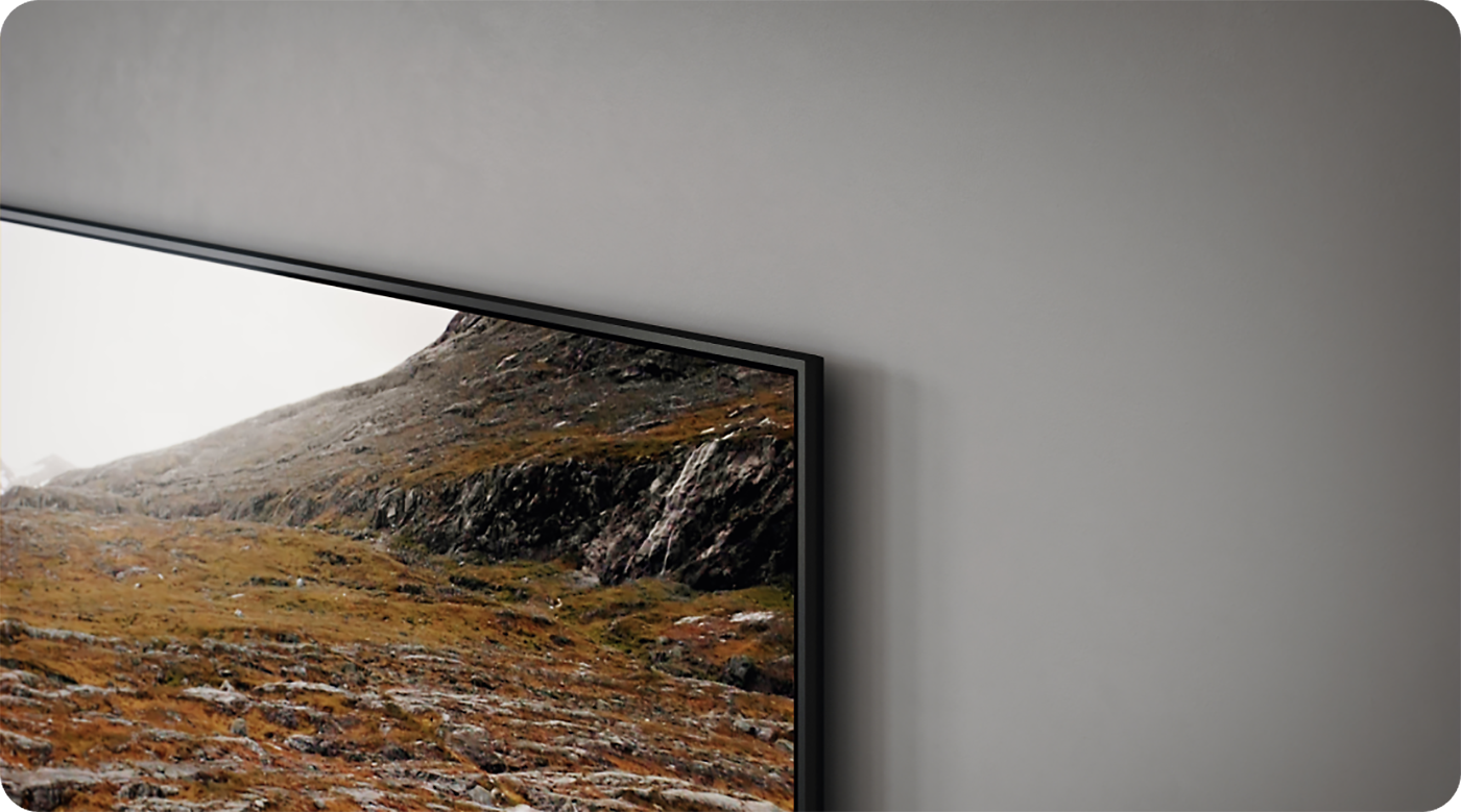 Närbild av en Samsung Q60C TV på en grå vägg