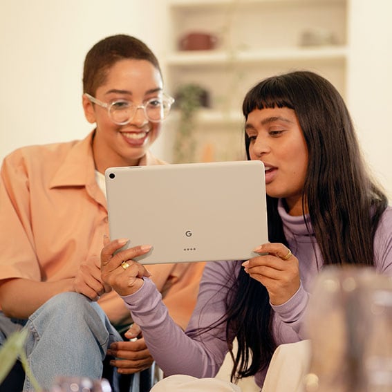 Två kvinnor som underhålls av Google Pixel Tablet