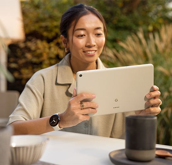 En kvinna utomhus som använder Google Pixel Tablet