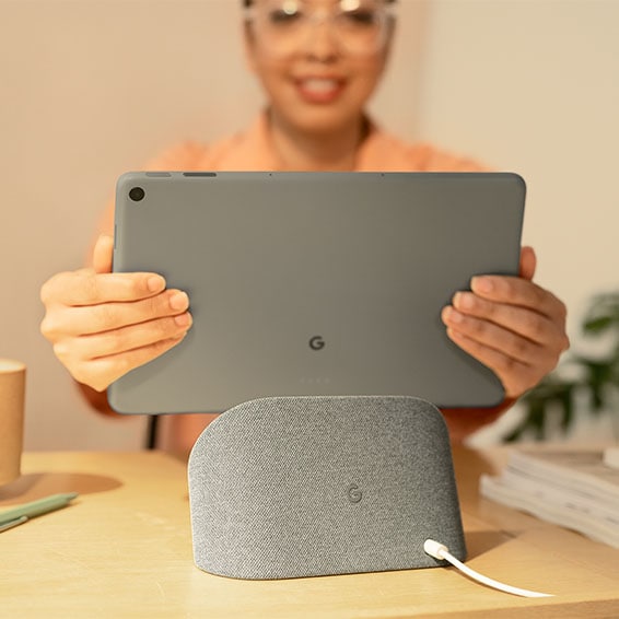 Google Pixel Tablet placeras i laddningsdockan av en kvinna