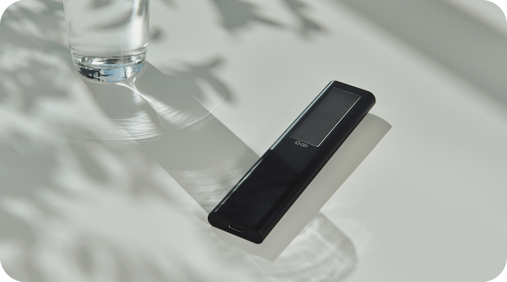 Samsung TV's SolarCell Remote on a table next to a glass of water