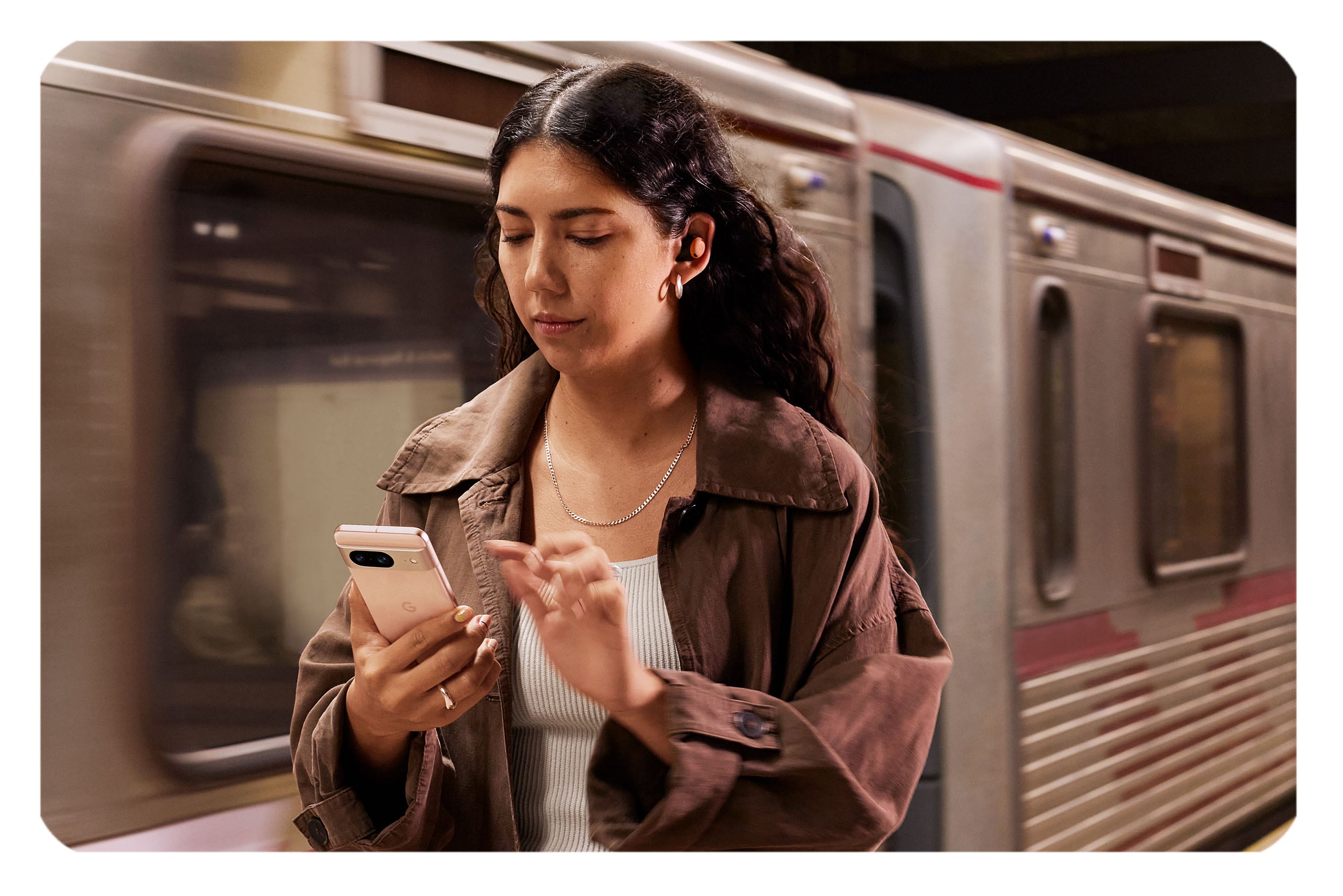Ung kvinna med Pixel 8 med en tunnelbana i bakgrunden