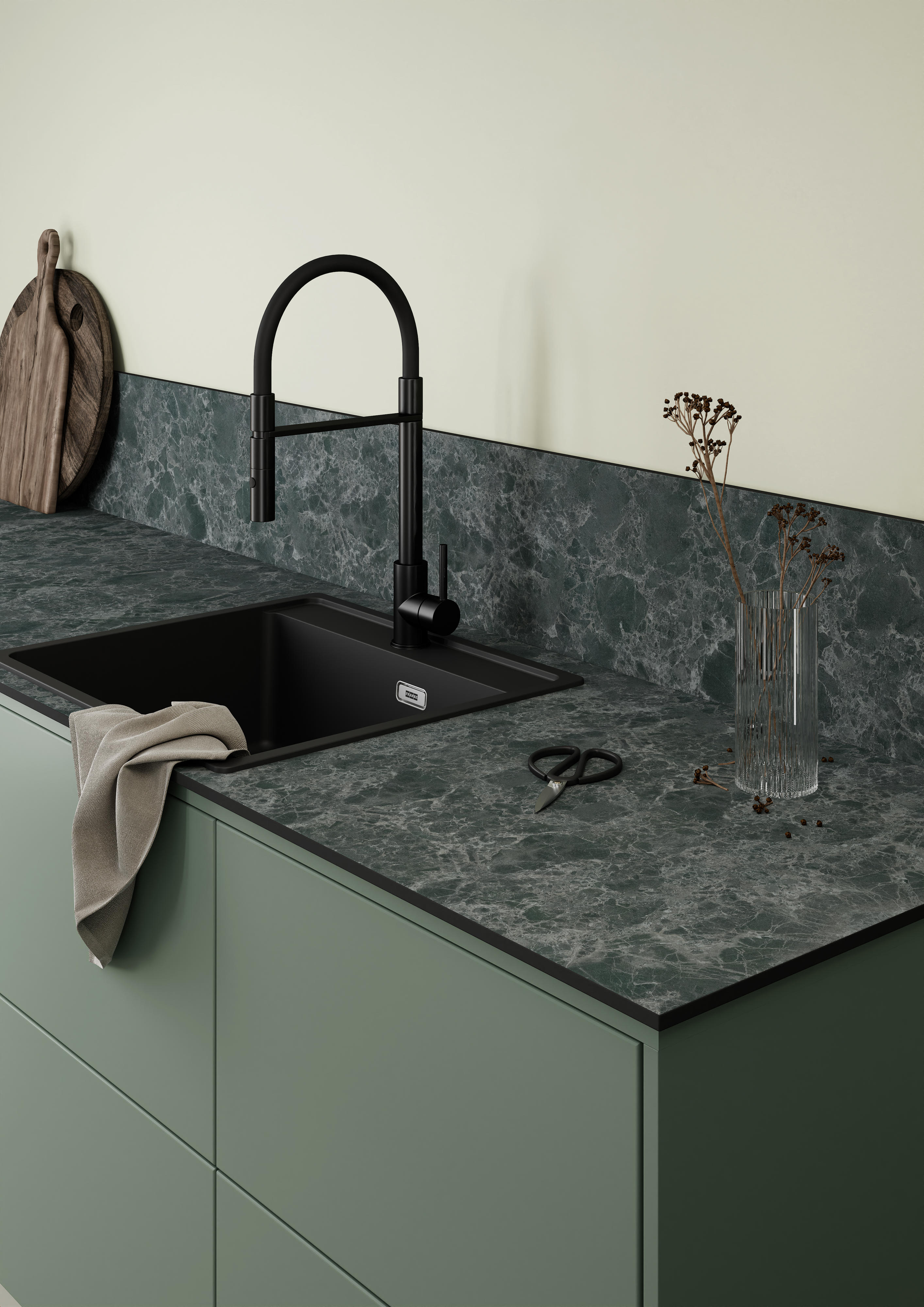 Green kitchen, sink and a dark grey worktop