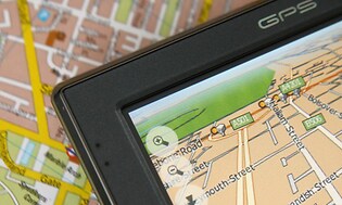 En GPS med en karta på displayen som ligger placerad ovanpå en "vanlig" traditionell karta. 