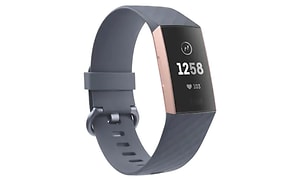 Ett smalt aktivitetsarmband i grå färg med roseguld på sidorna av displayen. Digital klocka med hjärtsymbol och fötter. 