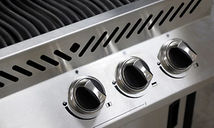 Svarta vred på en gasgrill i silver.