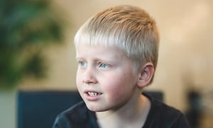En ljushårig pojke med kort frisyr som behöver klippas. 
