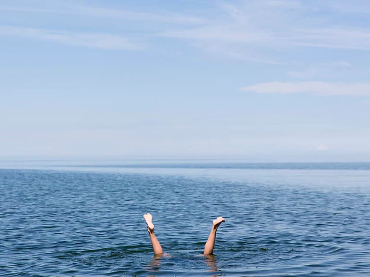 Två ben sticker upp från havet.