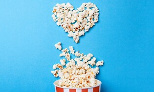 Popcorn formade som ett hjärta mot blå bakgrund.