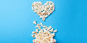 Popcorn formade som ett hjärta mot blå bakgrund.