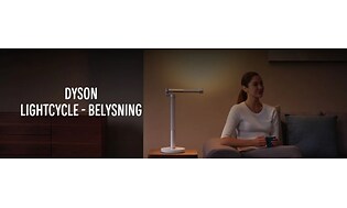 Dyson Lightcycle banner med kvinna som sitter i en soffa med sidobord och en bordslampa bredvid. 
