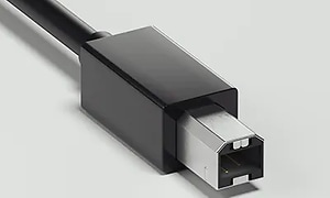 En svart USB-kabel med typ-b anslutning som är lite mer kvadratisk än den vanliga. 