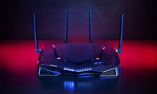En gamingrouter från Netgear med blått och rött ljus och fyra antenner.