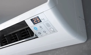 Närbild av en värmepumps knappar och temperaturreglage
