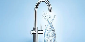 Grohe Blue vattenkran som fyller vatten i en genomskinlig karaff som bildas av vattnet. 