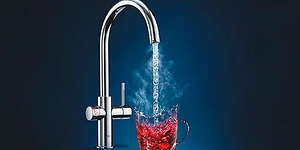 Grohe Red vattenkran med vatten som rinner ner i ett rött "fiktivt" glas.  