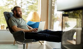 Man sitting on a chair with laptop in his lap