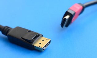 Närbild på DisplayPort och HDMI-kabel med blå bakgrund.