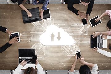 Multiple people around a table using cloud storage to work together