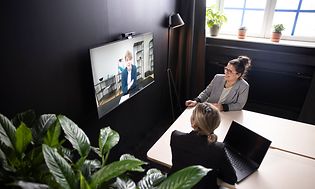 Två kvinnor deltar i ett videomöte med Konftel C2070-systemet