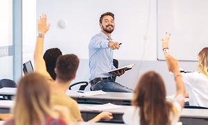 Airthings Wave Plus på en klassrumsvägg bakom en lärare.