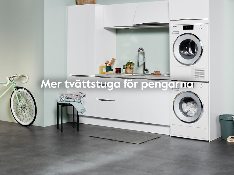 En vit tvättstuga med ljusgröna väggar och texten: "mer tvättstuga för pengarna". En grön cykel står vid ingången.