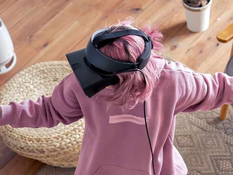 Gaming - Kvinna gamear med VR (Virtual Reality) i sitt vardagsrum.