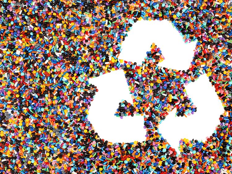 Plastbitar och en återvinningslogotyp