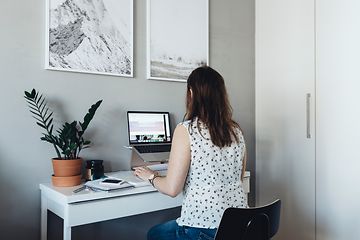 Kvinna på ett hemmakontor som arbetar på en bärbar dator