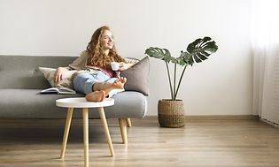 Kvinna som sitter i en soffa med en kaffekopp