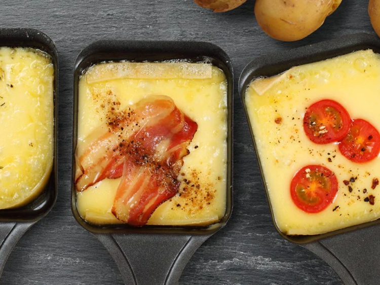 SDA - raclette - lifestyle - three raclette pans with cheese and toppings
