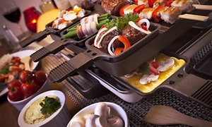 Close-up of square raclette with food cooking on it