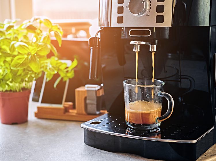 Kaffemaskin på ett bord och en kopp kaffe