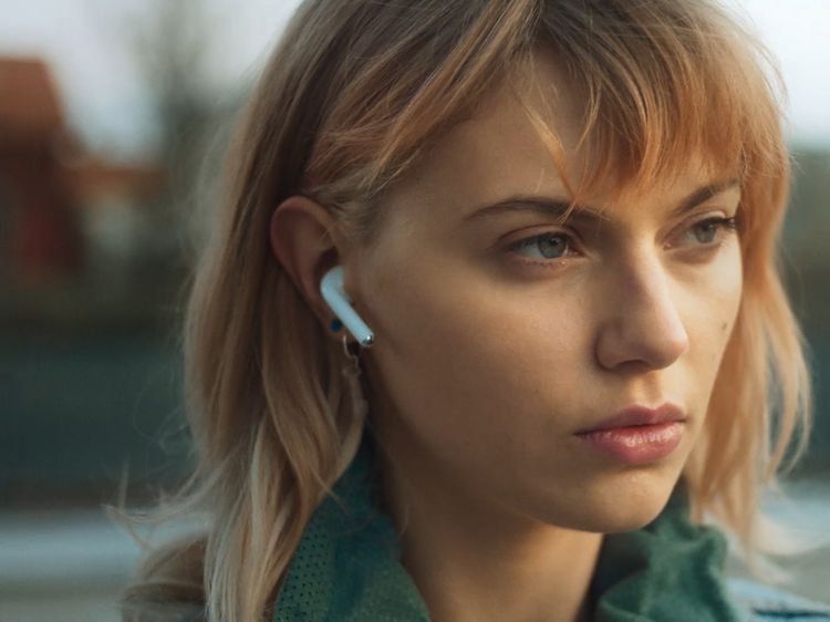 AirPods i öronen på en ung kvinna