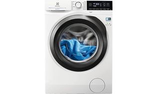 En vit tvättmaskin från Electrolux med blå tvtt inuti maskinen. 