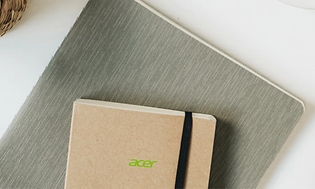 Två anteckningblock i olika storlekar från Acer på ett vitt skrivbord.