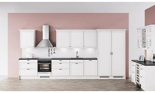 Vitt kök med silverfärgad vägghängd köksfläkt och rosa tapeter. 