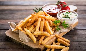 Pommes frites och såser serverat på ett bord