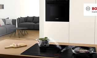 Bosch induktionshäll med inbyggd frånluftsfläkt och mat som tillagas på spisen.