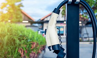 An EV-charger hanging in front of a house