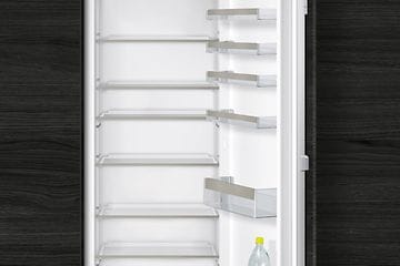 Inbyggt kylskåp från Siemens i vitt med öppen dörr och tomma hyllor. 