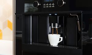Integrerad kaffemaskin som brygger en kopp kaffe. 