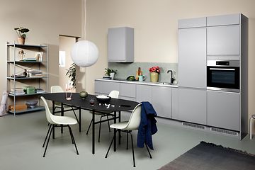 Ljusgrått EPOQ Integra kök i öppen kökslösning, med matbord, stolar och en bokhylla