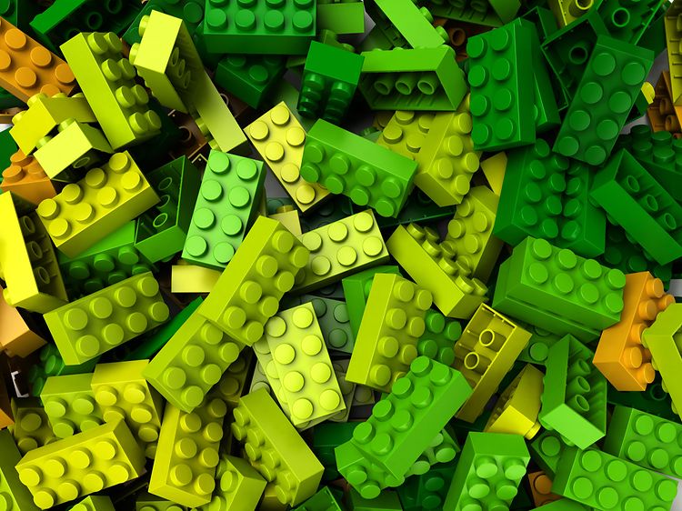 Lego-klossar i olika grön/gula nyanser i en hög. 