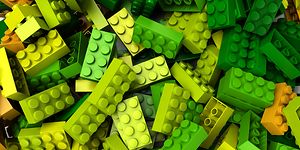 Lego-klossar i olika grön/gula nyanser i en hög. 
