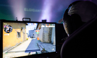 Gaming - En person som sitter framför en gamingdator.